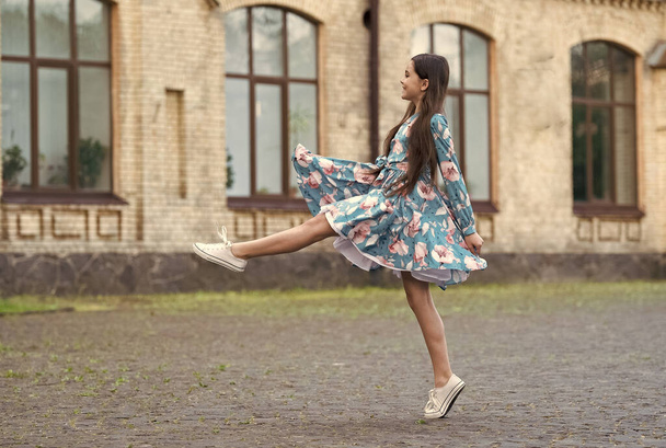 Girl summer dress flutters in motion urban background, making step concept - Fotó, kép