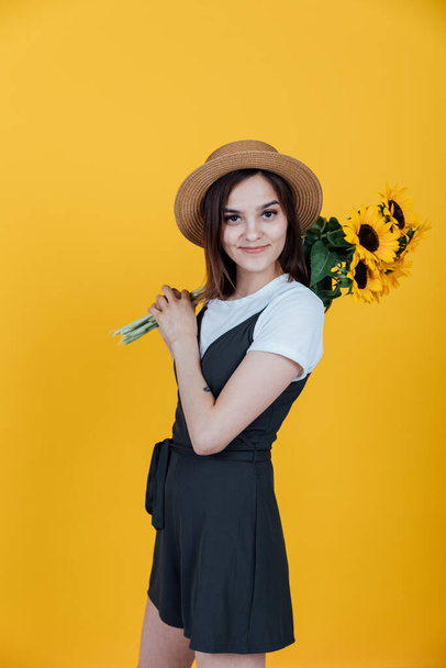 beautiful fashionable woman with yellow sunflower flowers - Zdjęcie, obraz