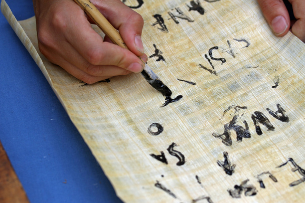 child writing with black ink on an Egyptian Papyrus parchment - Photo, Image