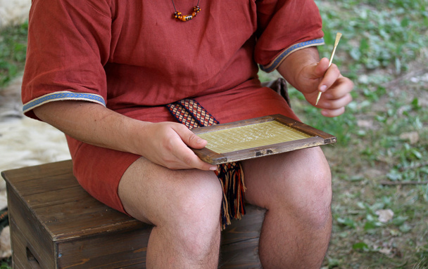 Genç kâtip erkek balmumu tablet üzerinde yazıyor - Fotoğraf, Görsel