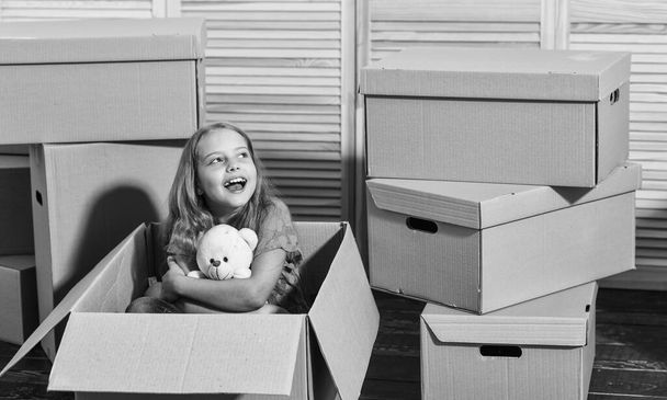 Resort apartment homes. Moving concept. new apartment. Cardboard boxes - moving to new house. purchase of new habitation. happy little girl with toy. happy child cardboard bo - Foto, afbeelding