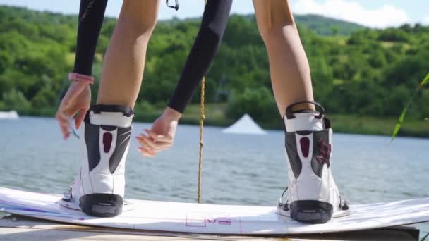 close-up van vrouw bindend laarzen van wakeboarding board - Video