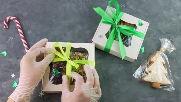 Mädchen auspacken Geschenkbox mit getrockneten Früchten Nüsse einzeln verpackt. Gesunde Ernährung. Weihnachtsfeier Feiertage Vorbereitung ökologisch natürlichen Snacks in weiblichen Händen. Hausgemachte Lebkuchen kandierten Süßigkeiten. - Filmmaterial, Video