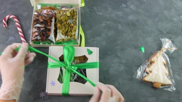Meisje uitpakken geschenkdoos met gedroogde vruchten individueel verpakt. Gezond voedsel dieet. Kerstviering vakantie voor te bereiden eco natuurlijke snack in vrouwelijke handen. Zelfgemaakte peperkoek gekonfijte snoepjes. - Video