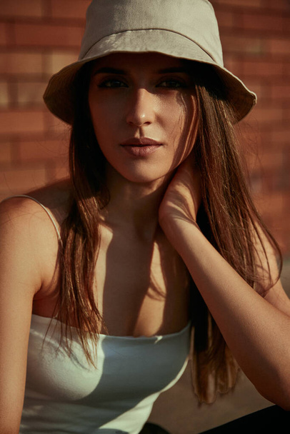 Young woman in hat looking at camera - Foto, Imagen