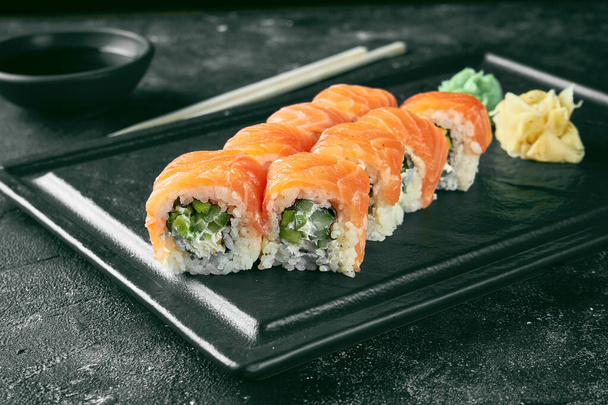 Uramaki sushi Philadelphia with salmon, cucumber and avocado. Classic Japanese cuisine. Food delivery. - Φωτογραφία, εικόνα