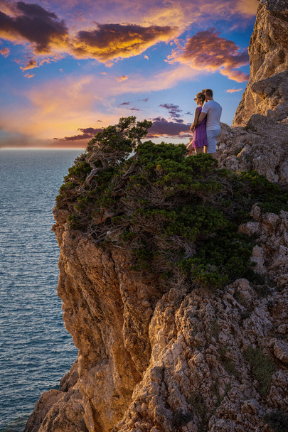 Fiatal pár élvezi a gyönyörű naplementét a sziklán, Cape Lefkas, Lefkada - Fotó, kép