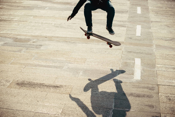 Asian woman skateboarder skateboarding in modern city - Photo, Image