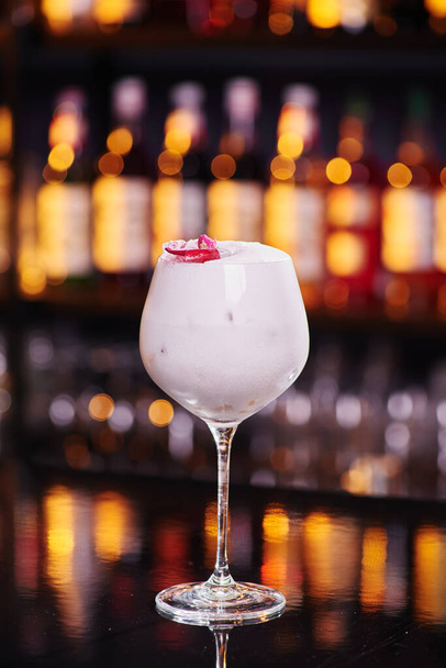 Kaunis valkoinen cocktail tyylikkäässä lasissa baaritiskillä yökerhossa, lähikuva. Tekstitila. - Valokuva, kuva