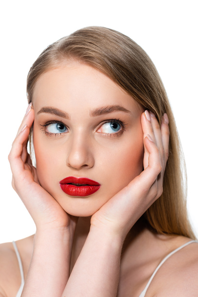 mujer joven con ojos azules y labios rojos mirando hacia otro lado aislado en blanco - Foto, Imagen