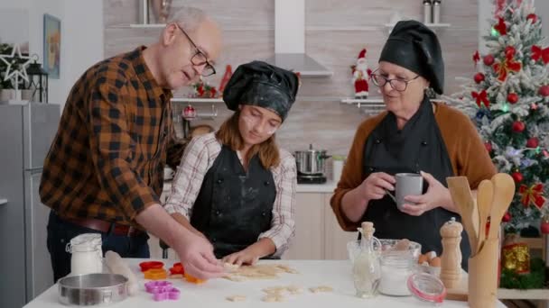 Grandparents teaching granddaughter how prepare gingerbread dessert shape - Footage, Video