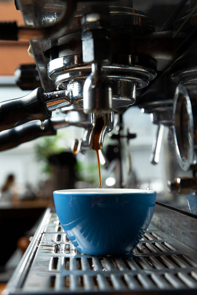 The coffee machine pours coffee into the cup. Close-up. Selective focus - Fotó, kép