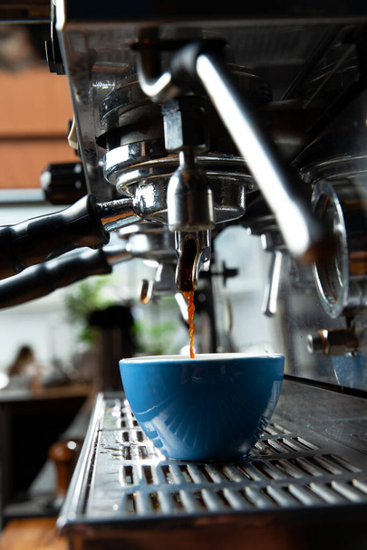 Кофеварка наливает кофе в чашку. Крупный план. Селективный фокус - Фото, изображение