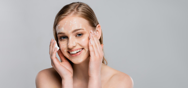 young happy woman with blue eyes and cleansing foam on face isolated on grey, banner - Фото, зображення