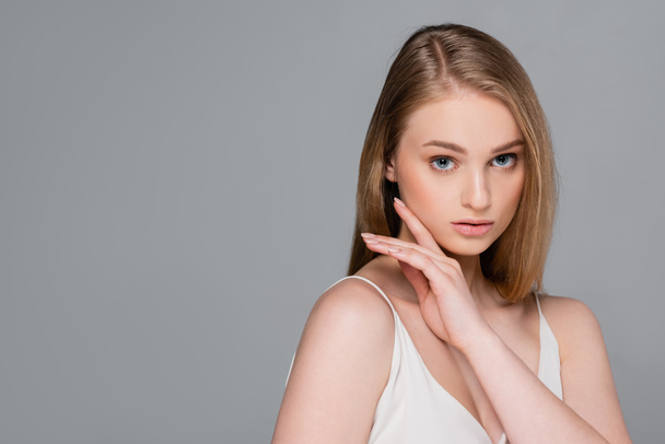 young pretty woman with makeup looking at camera isolated on gray - Photo, Image