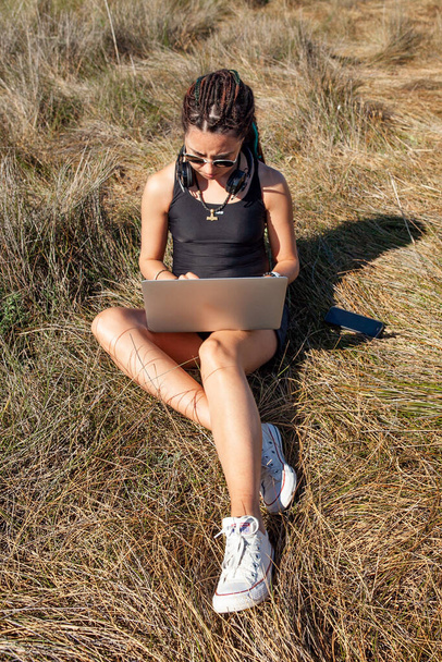 woman with laptop sitting on the grass in summer - Foto, Imagem