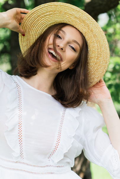 笑顔の女性は公園で太陽の帽子を保持  - 写真・画像