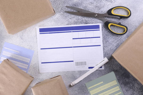 Close up shot of blank shipping application with prepared packages on the table. Waybill with blue label for domestic or international shipments. Copy space for text, background. - Foto, afbeelding