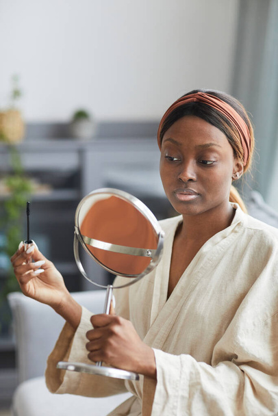 Nuori Afrikkalainen Amerikkalainen nainen tekee meikkiä kotona - Valokuva, kuva