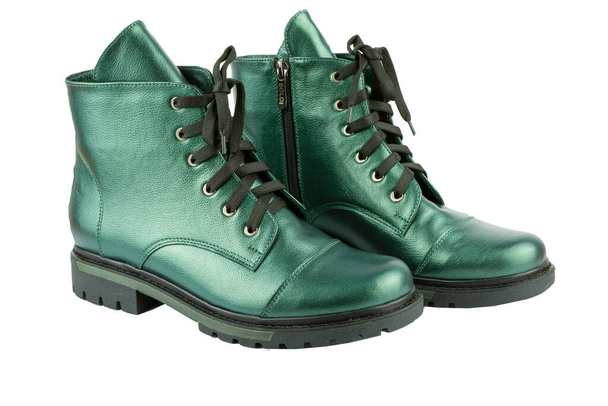 Green leather shoesisolated on white background. Winter and spring off-season boots. Stylish modern boot. Close-up. Laces, tractor sole. Casual style. Copy space. Pearlescent fashionable color. - 写真・画像