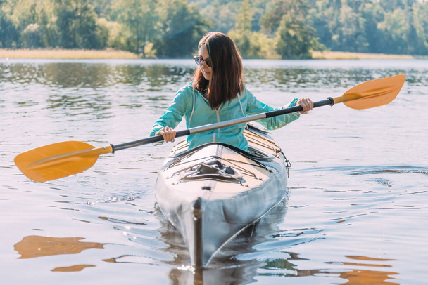 Woman kayaker traveler with paddle in hands. - Fotó, kép