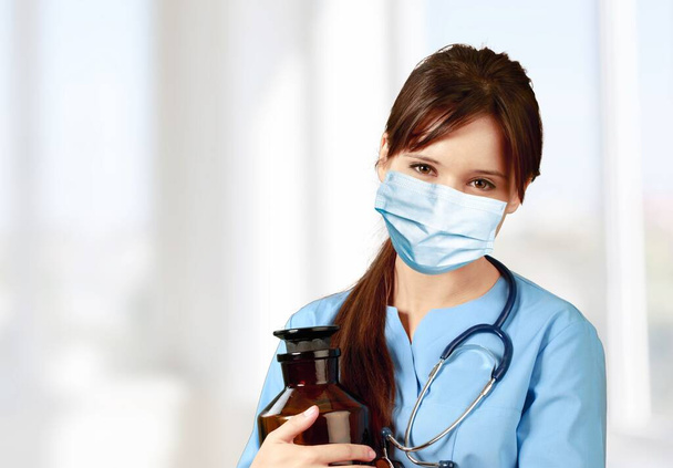 Portrait of a female doctor in blue robe and face mask - Foto, Imagem