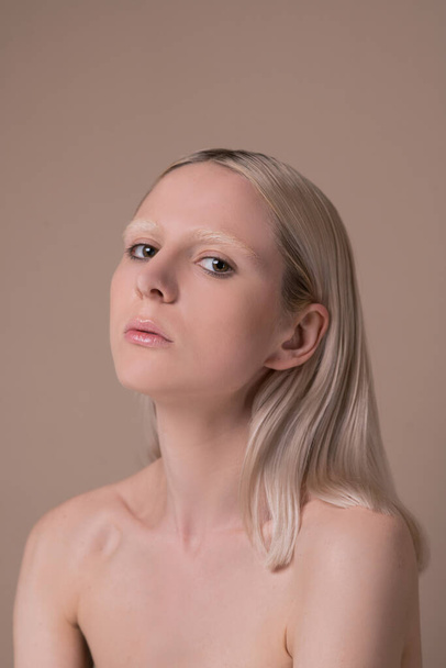 A pretty blonde girl with naked shoulders looking serious - Fotografie, Obrázek