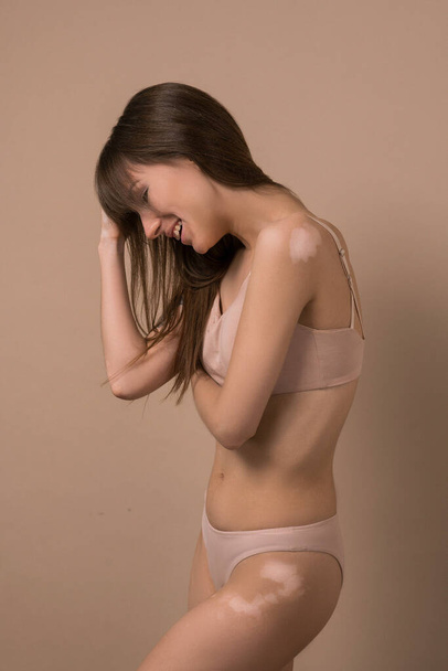 A slim long-haired woman in beige lingerie - Photo, Image