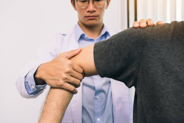 Los fisioterapeutas presionan el hombro del paciente para verificar si hay dolor. - Foto, imagen