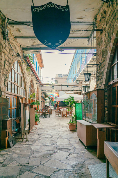 Chairs and tables in an outdoor cafe on a narrow street in Limassol, Cyprus. Nobody. - Fotoğraf, Görsel
