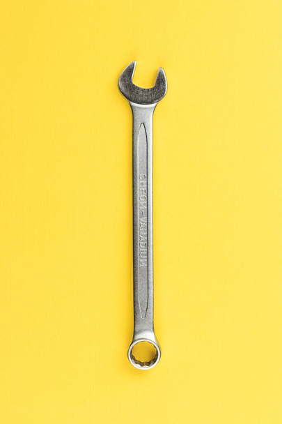 Wrench on bright yellow background, steel hand work tool - Foto, Imagem