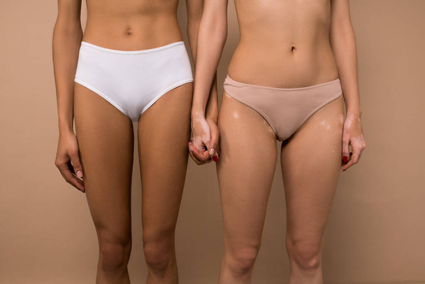 Foto ravvicinata di due figure femminili in lingerie che si tengono per mano - Foto, immagini