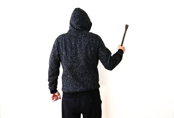 Criminel avec pied-de-biche près des portes. Robber à capuche sombre. - Photo, image