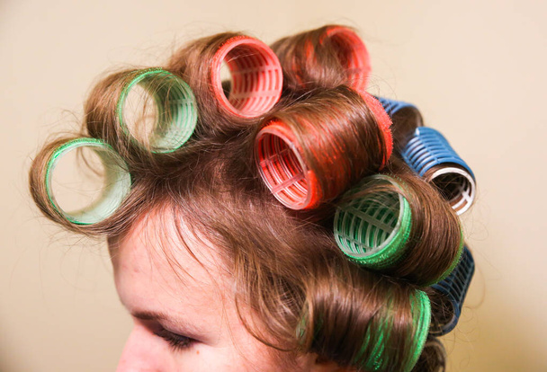 Frisadores de cabelo na cabeça da mulher. Fazendo penteado na moda em casa. - Foto, Imagem