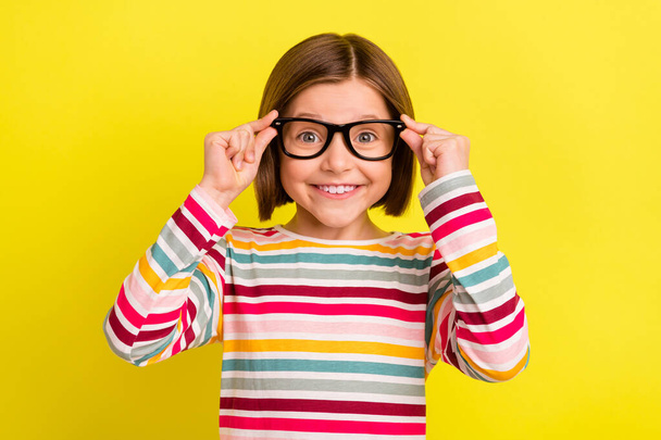 Photo of cheerful young happy small girl smile wear glasses face lens isolated on yellow color background - Valokuva, kuva