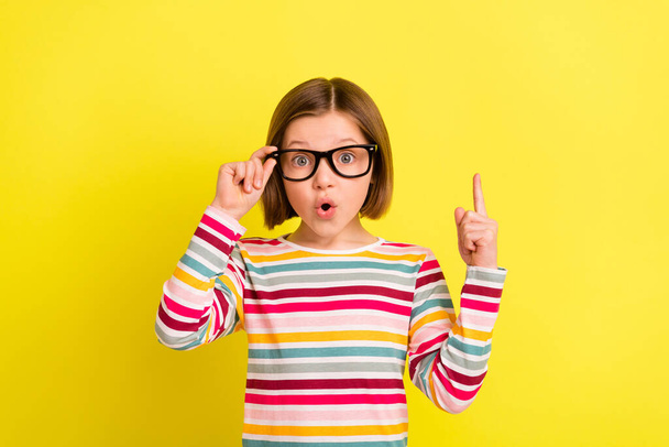 Photo of amazed shocked small girl point finger up idea smart wear glasses isolated on yellow color background - Foto, Imagem