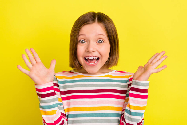 Photo of amazed young happy little girl shocked gift present good mood isolated on yellow color background - Foto, Imagen