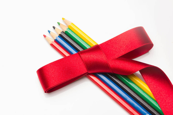Dar lápices de colores como regalos. Ramo de lápices de colores rodeados y envueltos en regalo con una cinta verde. Colores ecológicos - Foto, Imagen