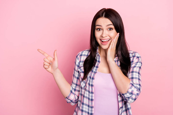 Portrait of attractive amazed cheerful girl demonstrating copy empty space ad isolated over pink pastel color background - Φωτογραφία, εικόνα