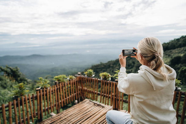 Woman is taking picture of sunrise at viewpoint in strawberry field in Mon Jam the north of Thailand - Fotografie, Obrázek