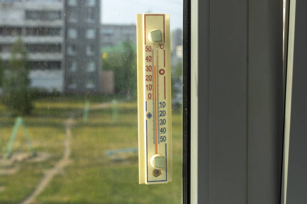 Thermometer außerhalb des Fensters zeigt ungewöhnlich heiße Außentemperatur an - Foto, Bild