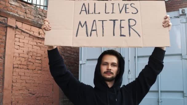 Biały mężczyzna protestuje na ulicy z megafonami i znakami - Materiał filmowy, wideo