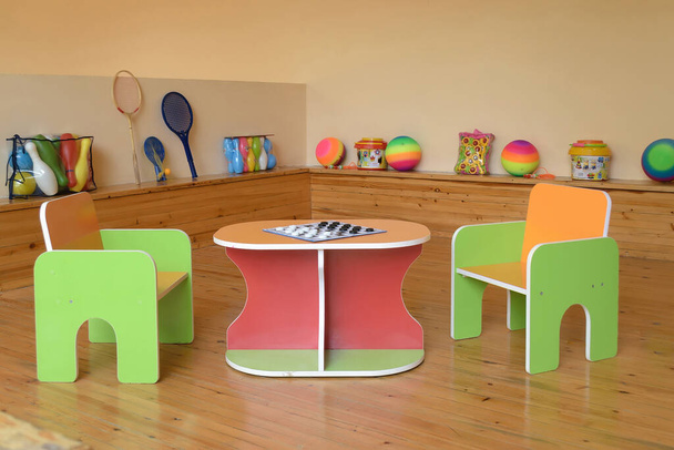 Kinderspielplatz im Kindergarten mit verschiedenen Spielsachen, zwei Stühlen und einem Tisch, auf dem Steine liegen - Foto, Bild