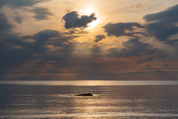 auringonlasku meressä pilvet ja tyyntä vettä pinnalla, jonka auringonvalo heijastaa luomalla valotie - Valokuva, kuva