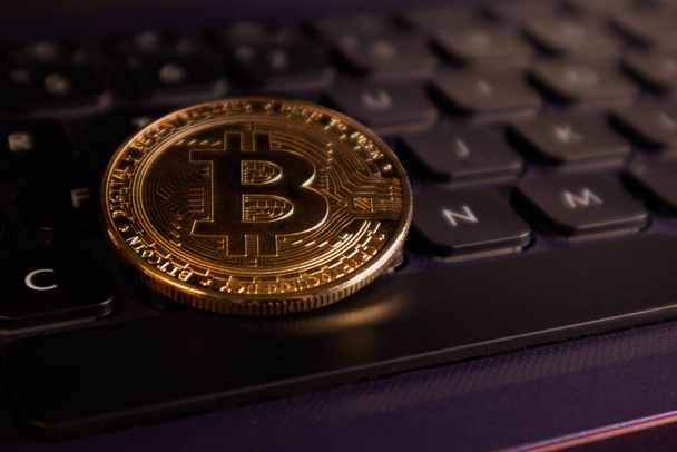 Nahaufnahme einer Bitcoin-Goldmünze auf einer Computertastatur. Weicher Fokus. - Foto, Bild