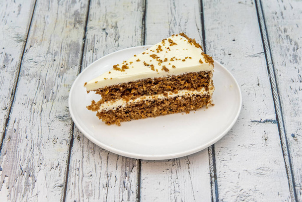 great portion of carrot cake with two layers of cake with nuts with a layer of sugary frosty filling - Φωτογραφία, εικόνα