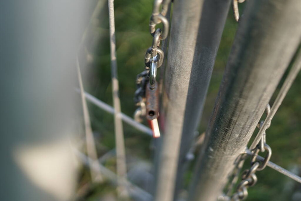 The lock that was released from the chain that bound the iron door. Sign of freedom. The photo is take with bokeh foreground - Photo, Image