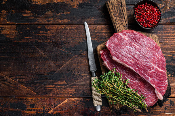Syrový steak se svíčkovou nebo Picanha steak na dřevěné desce s tymiánem. Tmavé dřevěné pozadí. Horní pohled. Kopírovat prostor - Fotografie, Obrázek