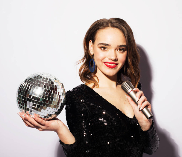 pretty woman holding disco ball and microphone, fun party, karaoke, holiday. - Foto, Bild