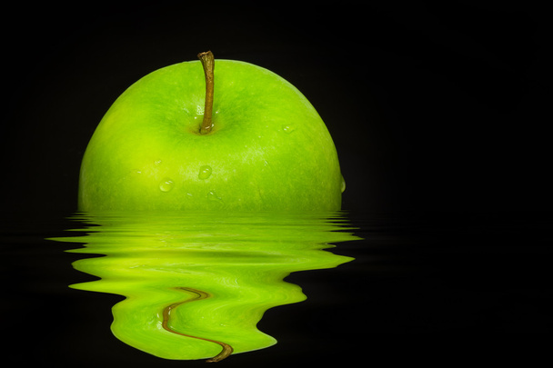 Fresh green apple on black background with water reflection - Foto, imagen